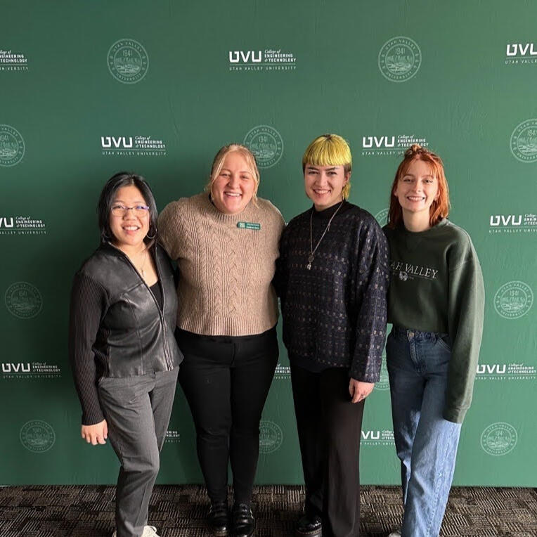 four women in front of a green background