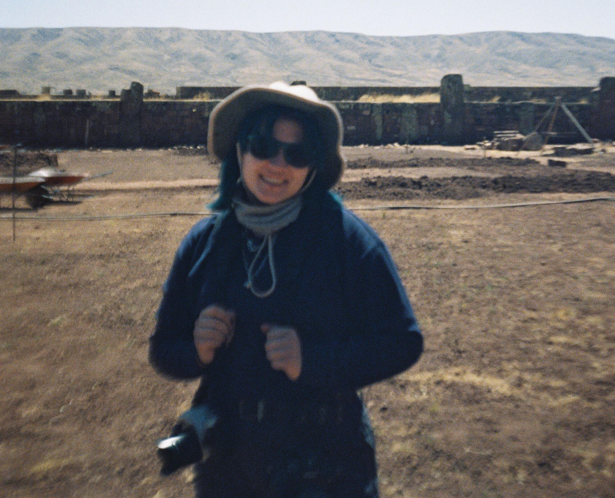 woman holding cameras on an archaeological site